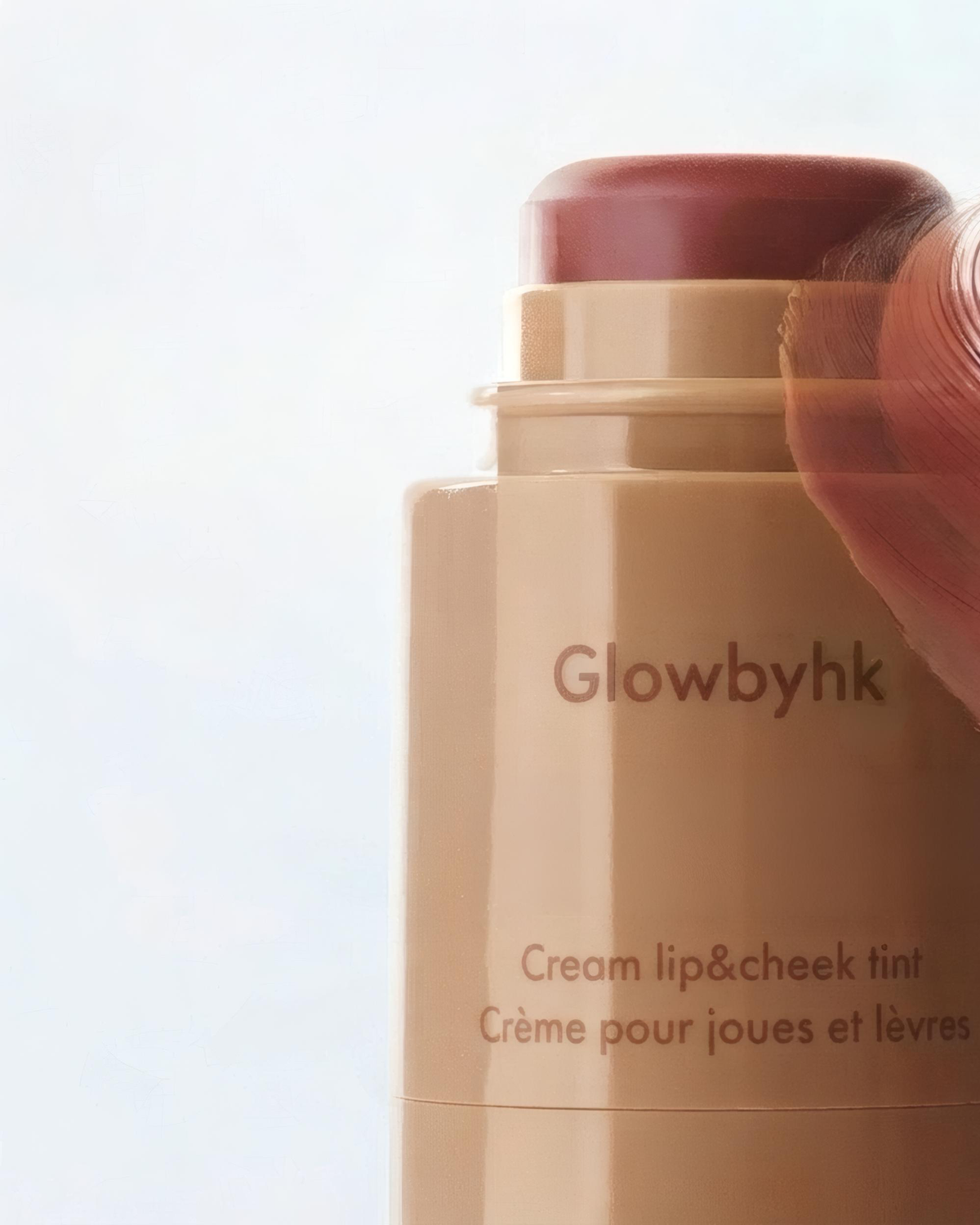 Burnt Honey Cream Blush held beside a makeup brush
